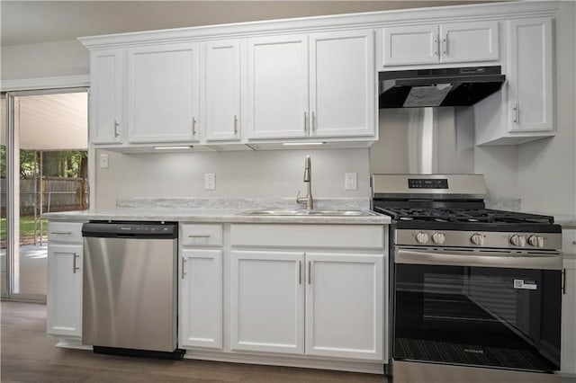 1452 Morlee Dr E, Mobile, AL 36618 - kitchen with stainless steel appliances, under cabinet range hood, a sink, white cabinetry, and light countertops