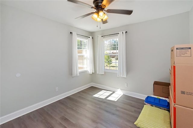 empty room with ceiling fan, baseboards, and wood finished floors