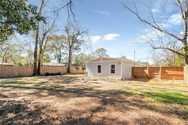 rear view of house featuring a fenced backyard and a lawn