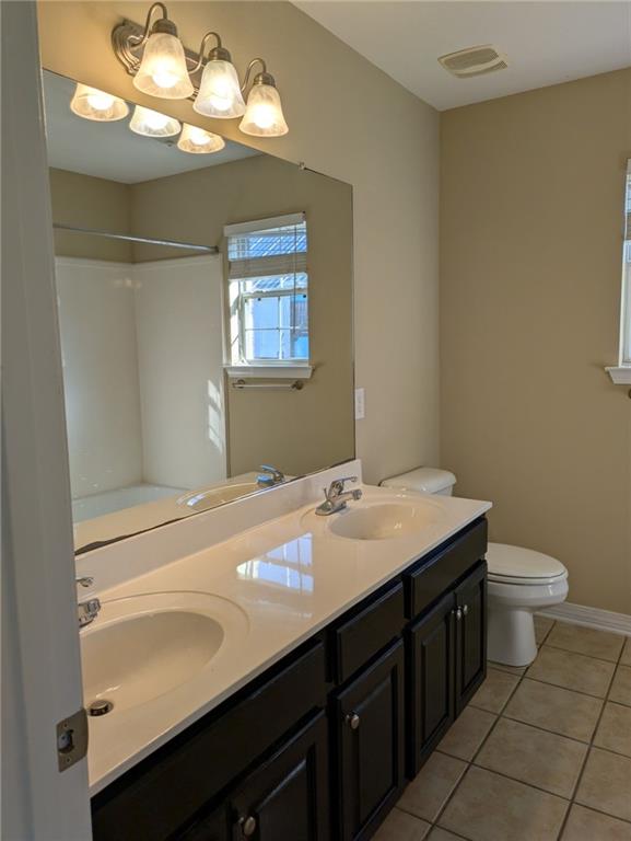 bathroom with tile patterned flooring, vanity, and toilet