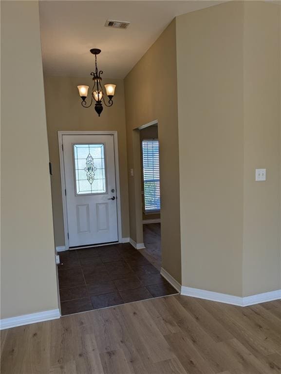 foyer with wood-type flooring and an inviting chandelier