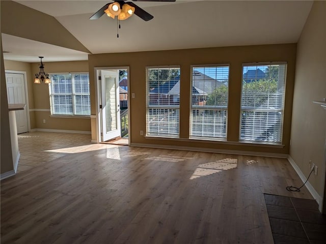 interior space featuring hardwood / wood-style flooring, plenty of natural light, ceiling fan with notable chandelier, and vaulted ceiling