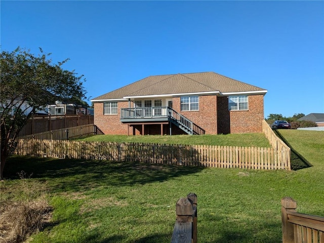 rear view of house featuring a yard and a deck