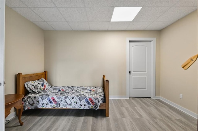 bedroom with wood-type flooring and a paneled ceiling