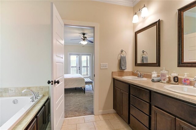 bathroom with ceiling fan, double vanity, ornamental molding, a bathtub, and tile patterned flooring