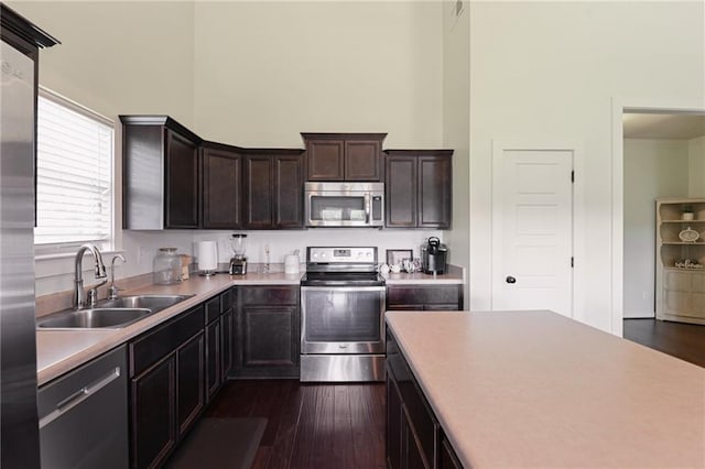 kitchen featuring sink, dark hardwood / wood-style flooring, dark brown cabinets, and stainless steel appliances