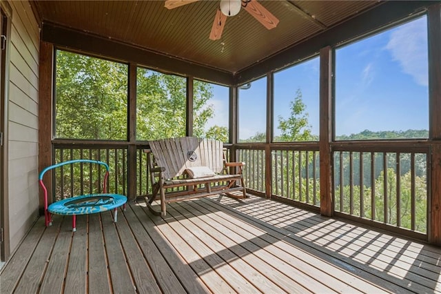 unfurnished sunroom with wooden ceiling and ceiling fan