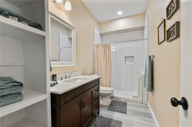 bathroom with toilet, a shower with curtain, hardwood / wood-style floors, and vanity