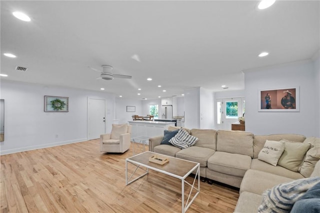 living room with light wood-type flooring and ceiling fan