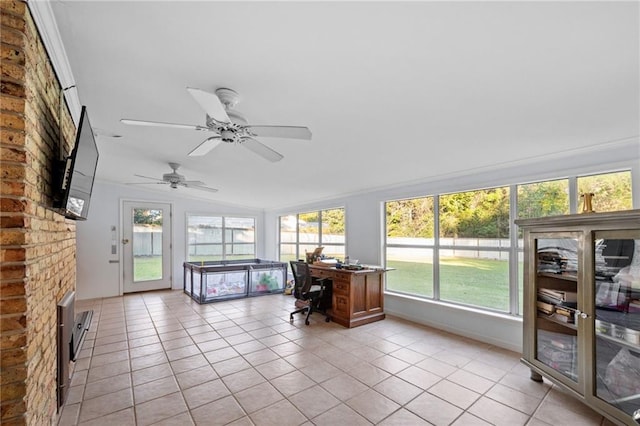 sunroom featuring a wealth of natural light, a fireplace, ceiling fan, and lofted ceiling