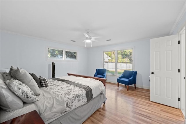 bedroom featuring ceiling fan, crown molding, and light hardwood / wood-style flooring