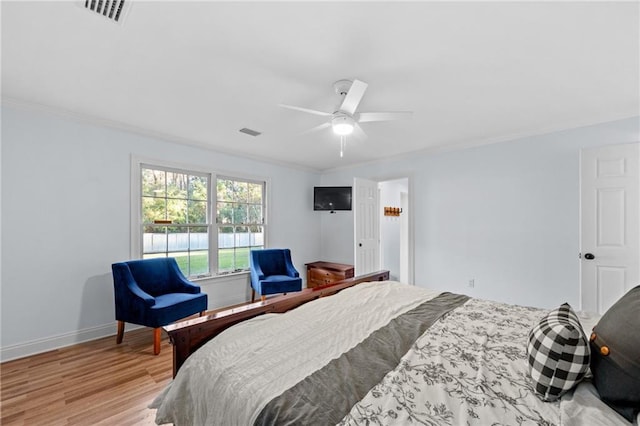 bedroom featuring ceiling fan, light hardwood / wood-style floors, and ornamental molding