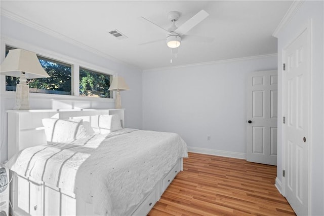 bedroom with ceiling fan, ornamental molding, and light hardwood / wood-style flooring