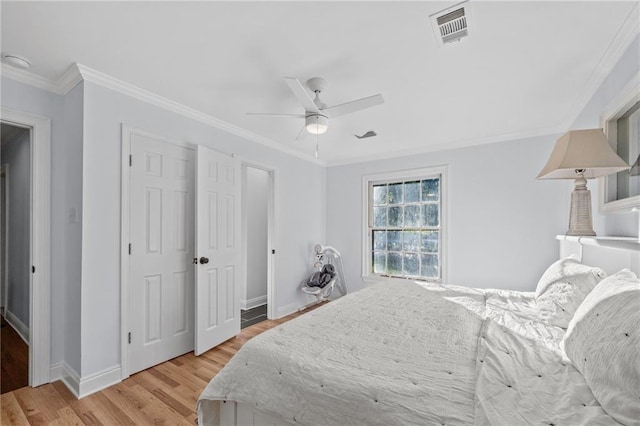 bedroom with light hardwood / wood-style flooring, ceiling fan, and crown molding