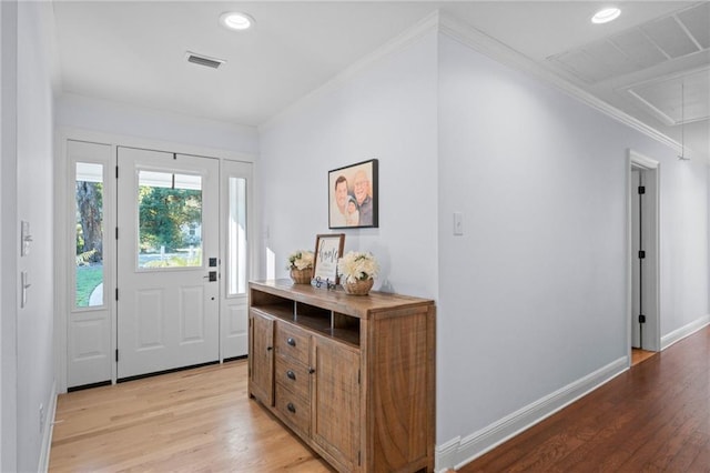 entrance foyer featuring crown molding and light hardwood / wood-style flooring