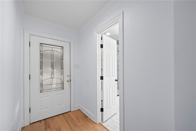 entryway with light hardwood / wood-style flooring and crown molding