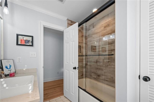 bathroom with sink, combined bath / shower with glass door, wood-type flooring, and crown molding