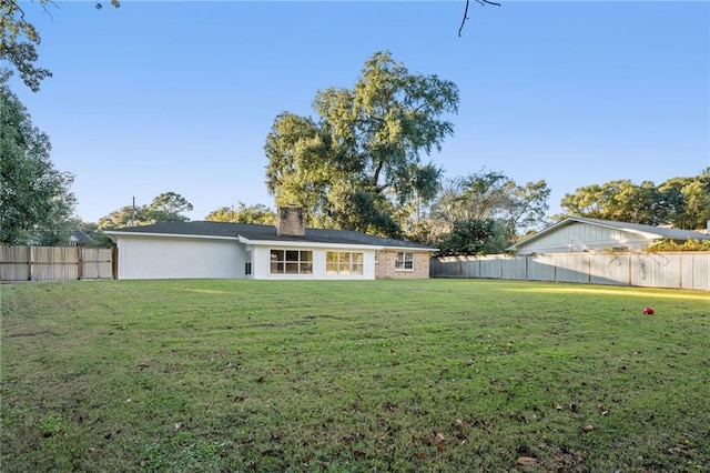 back of house featuring a lawn