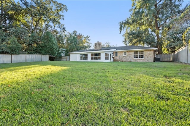 rear view of house featuring a lawn