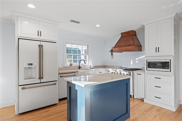 kitchen featuring a center island, light hardwood / wood-style flooring, high end appliances, and custom exhaust hood