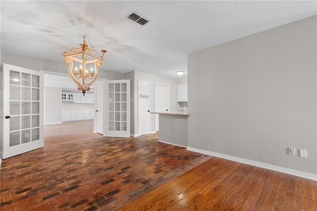 interior space featuring french doors, a chandelier, and dark hardwood / wood-style floors