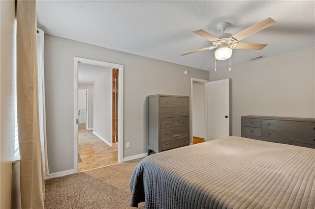 carpeted bedroom featuring ceiling fan and a textured ceiling