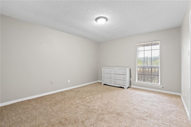 carpeted spare room featuring a textured ceiling