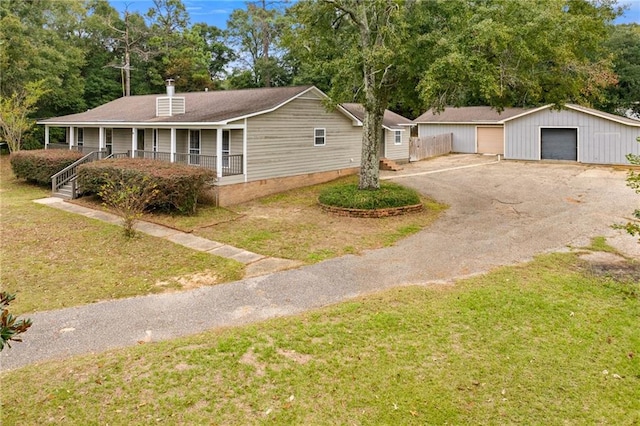 single story home with an outbuilding, a front lawn, a porch, and a garage