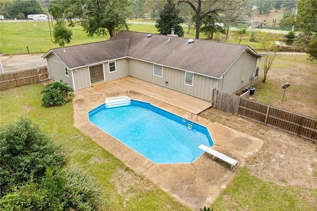 view of swimming pool with a diving board, a deck, and a yard