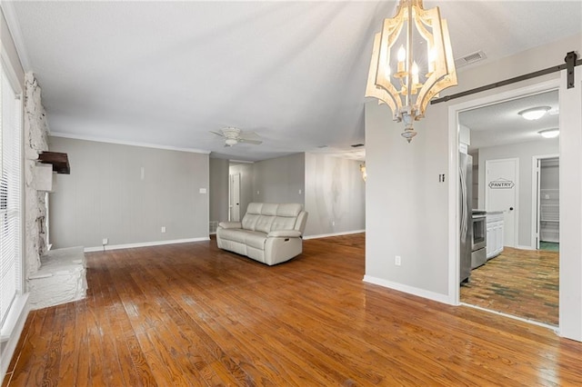 unfurnished living room with ceiling fan with notable chandelier, hardwood / wood-style flooring, and crown molding