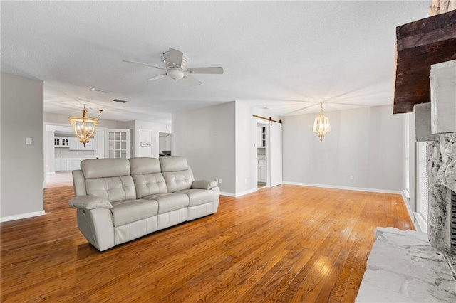 living room featuring hardwood / wood-style flooring, ceiling fan, and a barn door