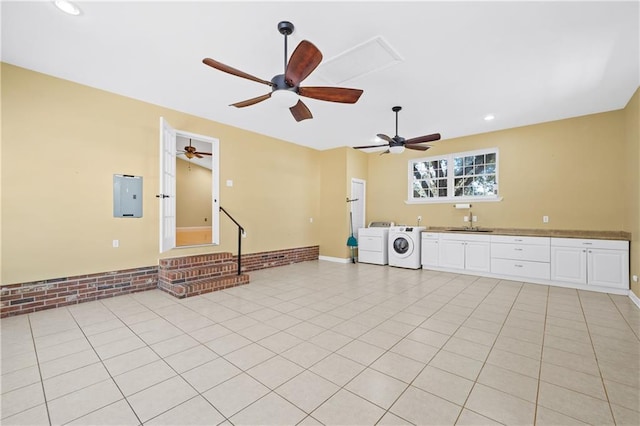 unfurnished living room featuring light tile patterned floors, recessed lighting, separate washer and dryer, a sink, and electric panel