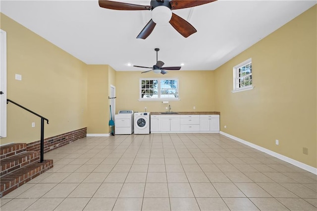 interior space with light tile patterned floors, baseboards, a sink, and independent washer and dryer