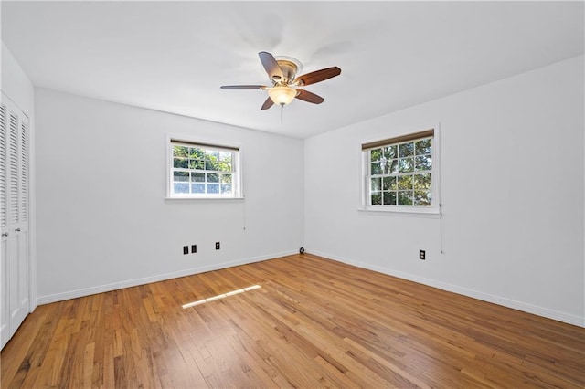 unfurnished bedroom featuring light wood finished floors, ceiling fan, baseboards, and a closet