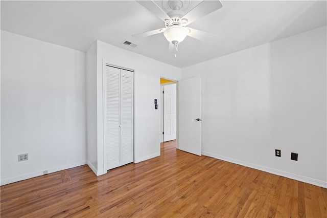 unfurnished bedroom with visible vents, baseboards, light wood-style flooring, ceiling fan, and a closet