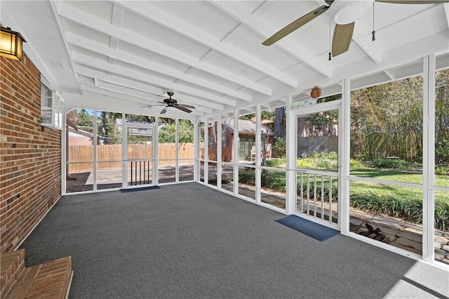 unfurnished sunroom with beam ceiling and a ceiling fan