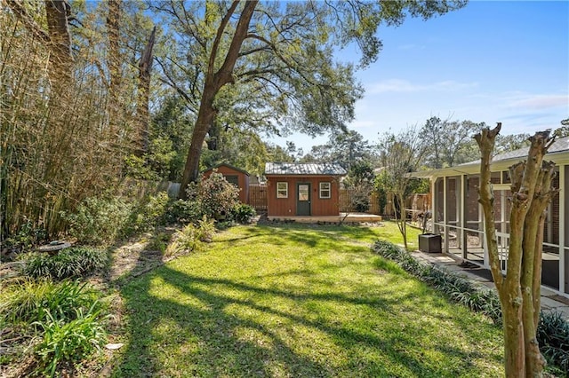 view of yard featuring a sunroom, fence, and an outdoor structure