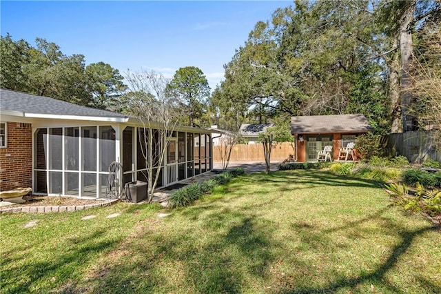 view of yard featuring a sunroom and fence