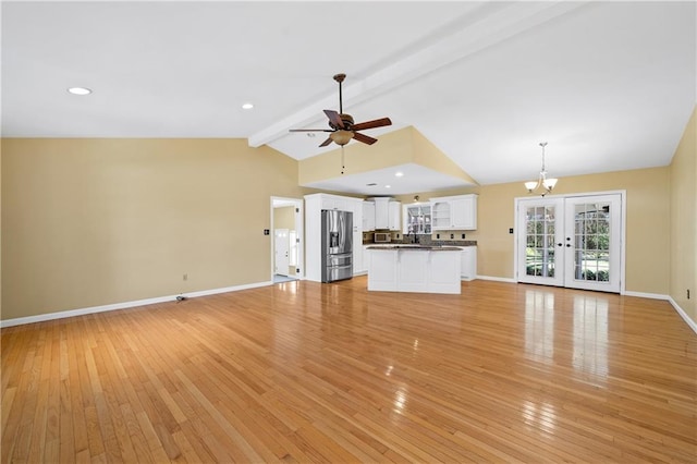 unfurnished living room featuring french doors, lofted ceiling with beams, light wood-style floors, baseboards, and ceiling fan with notable chandelier