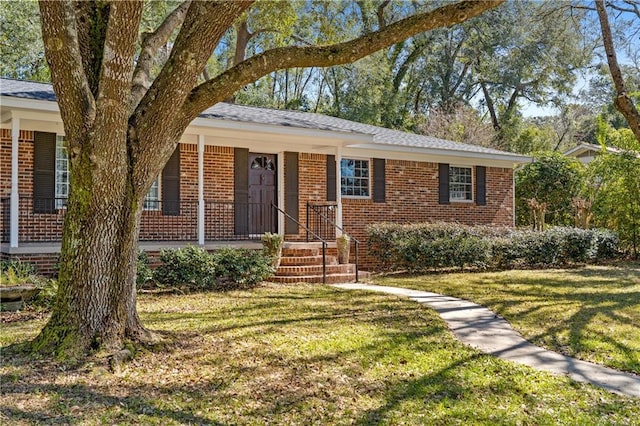 ranch-style house featuring brick siding, a porch, and a front yard