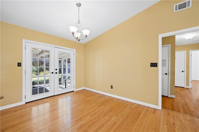 unfurnished dining area featuring light wood-style flooring, visible vents, baseboards, and french doors