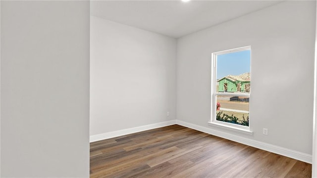 unfurnished room with baseboards and wood finished floors