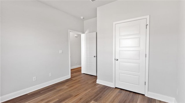 unfurnished bedroom featuring baseboards and wood finished floors