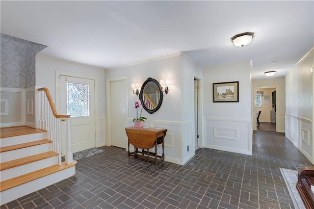 608 Montclaire Way, Mobile, AL 36609 - foyer featuring brick patterned floors, wainscoting, stairway, and a decorative wall