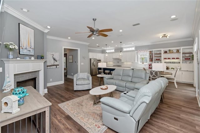 9102 Magnolia Ct, Spanish Fort, AL 36527 - living area featuring ceiling fan, dark wood-style floors, recessed lighting, ornamental molding, and a brick fireplace