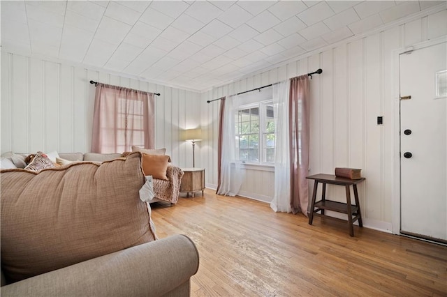 living area featuring wood finished floors, ornamental molding, and baseboards