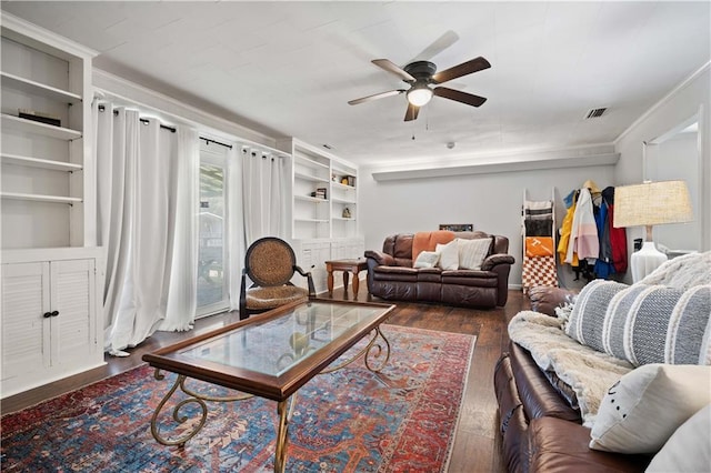 living room with a ceiling fan, built in shelves, and hardwood / wood-style flooring