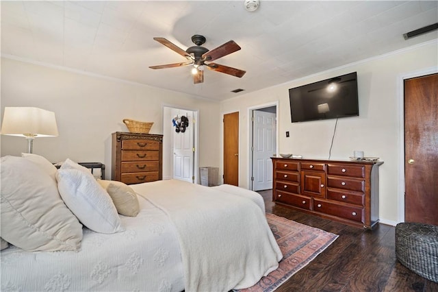 bedroom featuring dark wood-type flooring, ornamental molding, ceiling fan, and baseboards