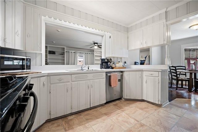 kitchen with stainless steel appliances, light countertops, a sink, crown molding, and a ceiling fan