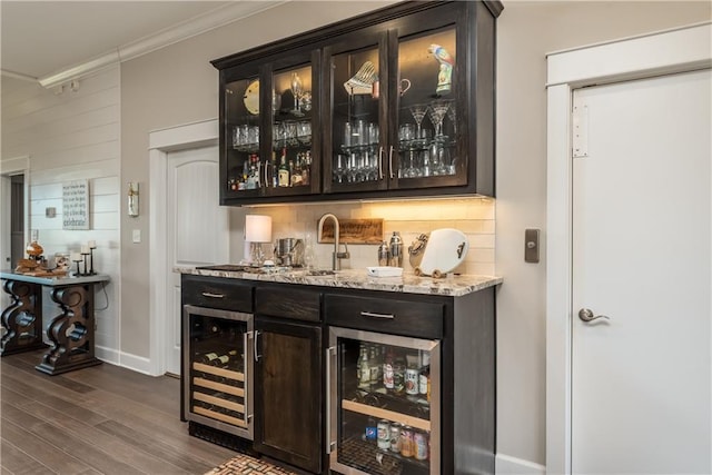 bar with beverage cooler, wet bar, decorative backsplash, and a sink